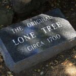 Legend of Lone Tree Cemetery - Funeral Services - Granite Marker under the Lone Tree with the engraved date of 1700.