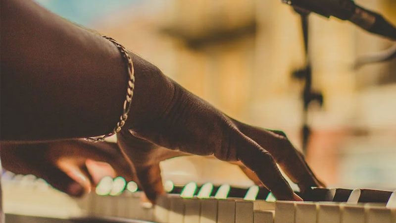 Photo of hands on a piano.