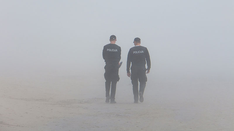 Photo of two policemen walking in the fog