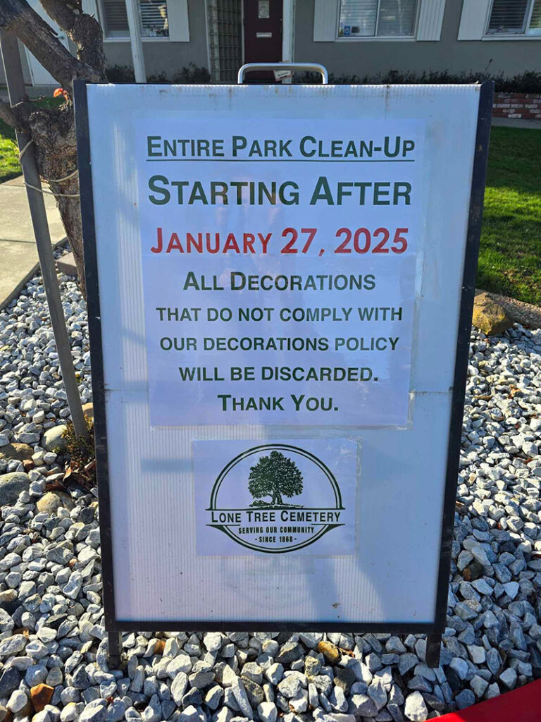 photo of a sign alerting guests and families about the clean up of holiday decorations at Lone Tree Cemetery on January 27, 2025